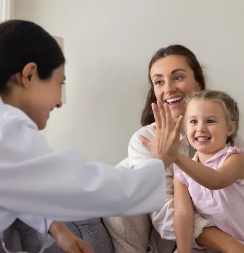 Enfant souriant donnant un high-five à un médecin